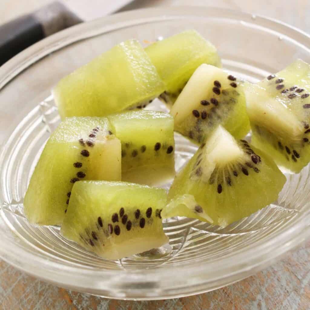 pieces of kiwi fruit cut up on a glass plate for my dog