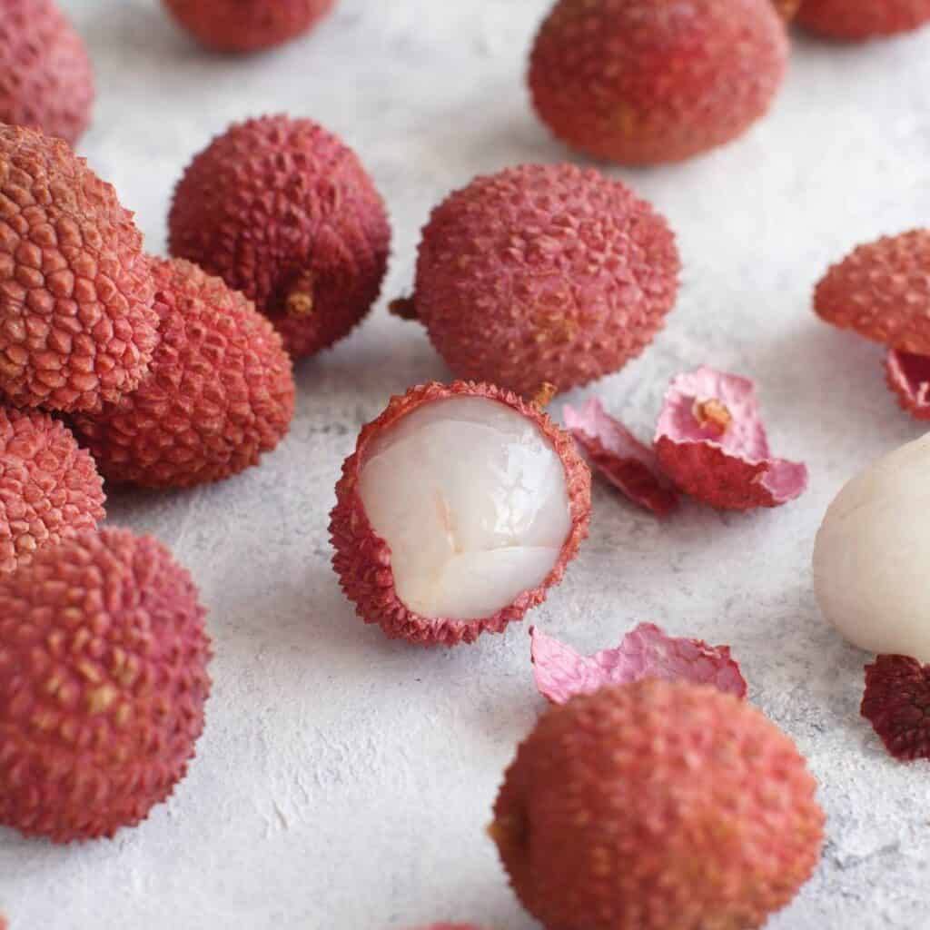 lychee fruits cut open to show the differences between these and rambutans